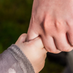 Adult holding child hand