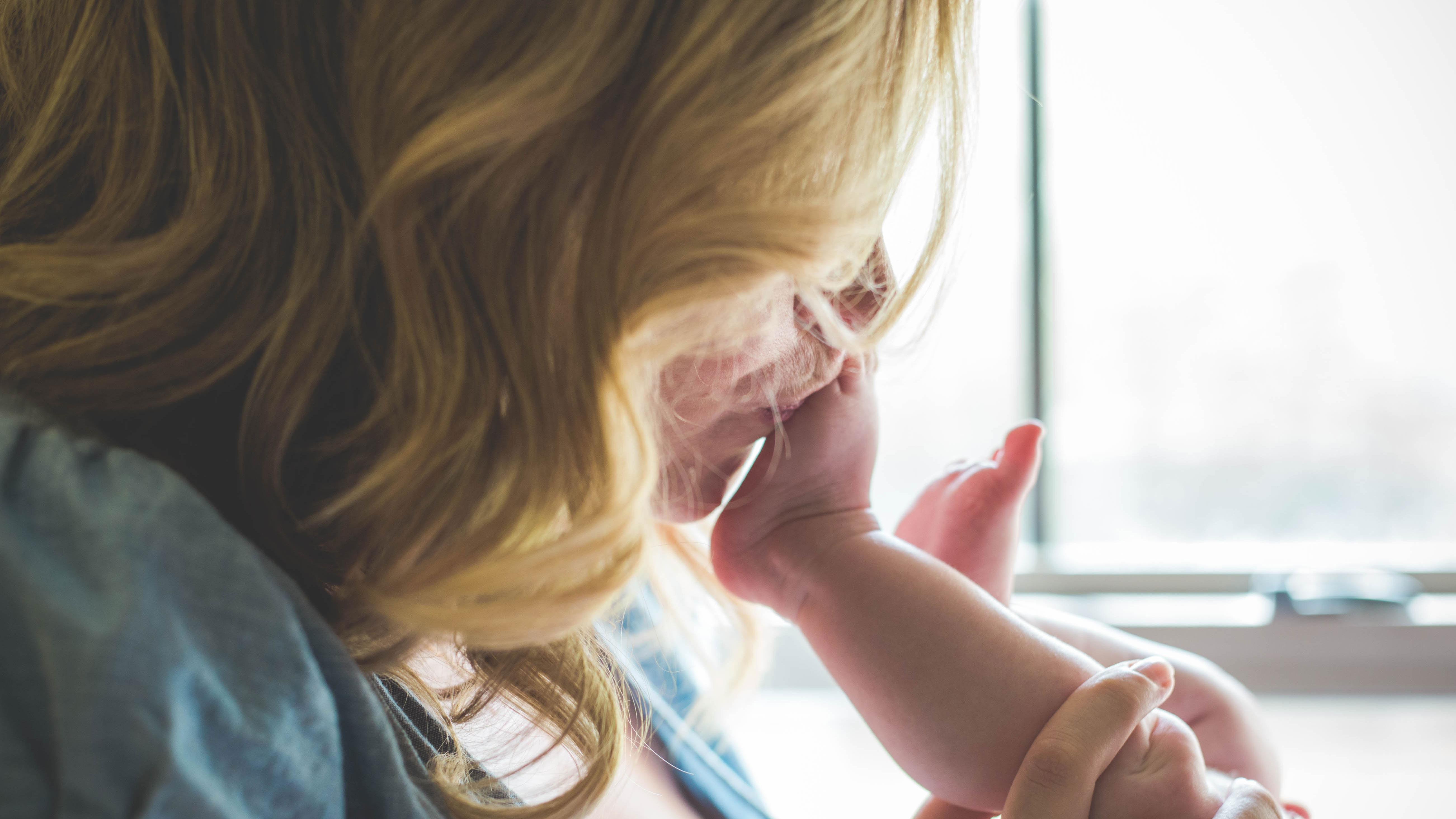 Mum kisses baby's foot.