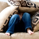 Child hiding in couch cushions