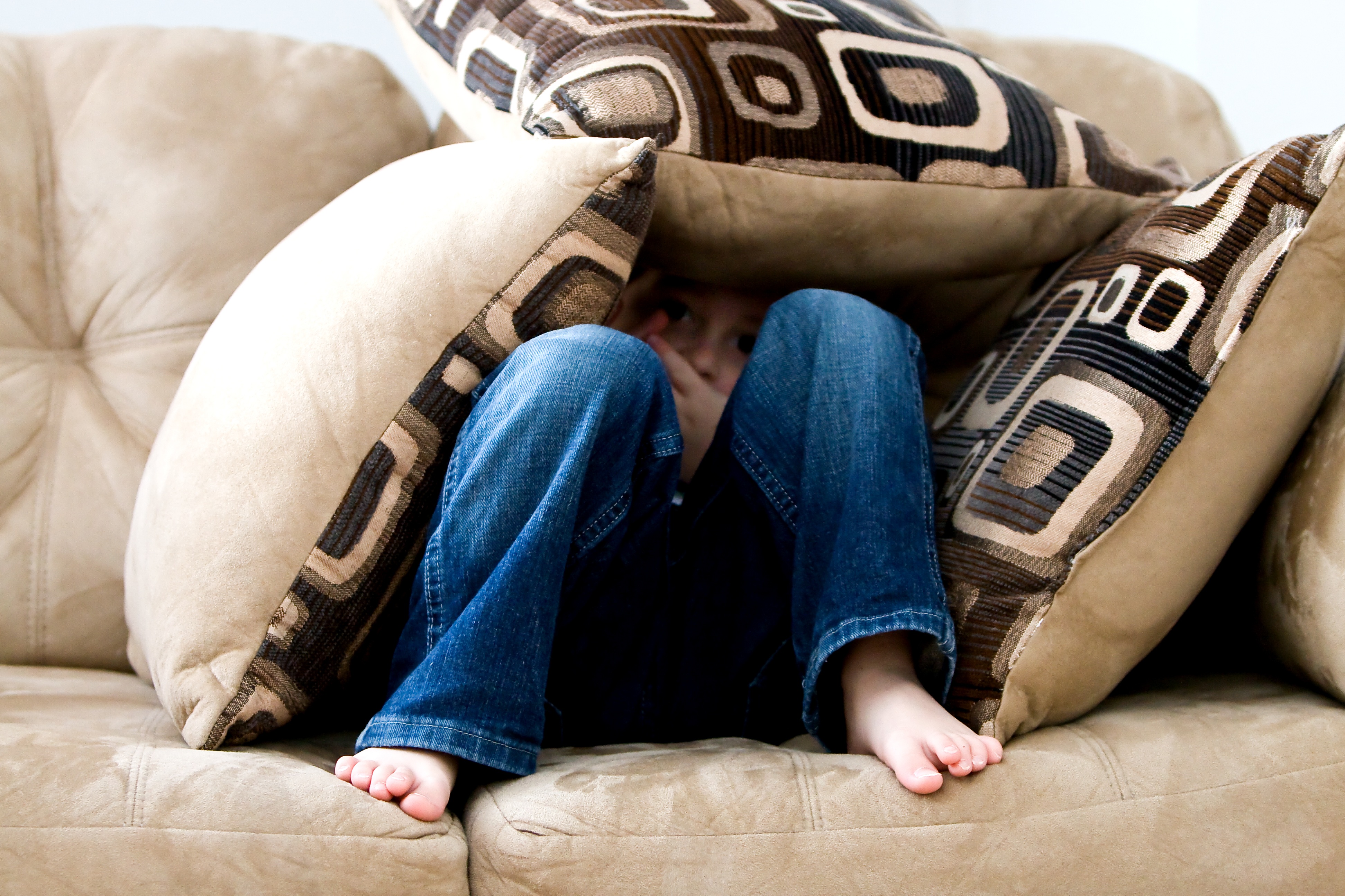 Child hiding in couch cushions