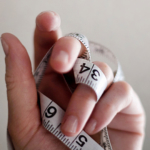 hand with measuring tape