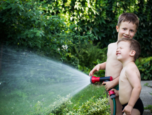 two-boys-playing-with-a-hose-outside1440