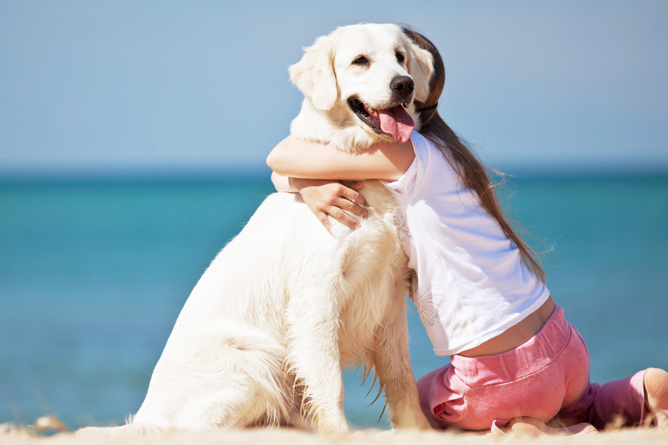 girl-hugging-dog-on-beach2160