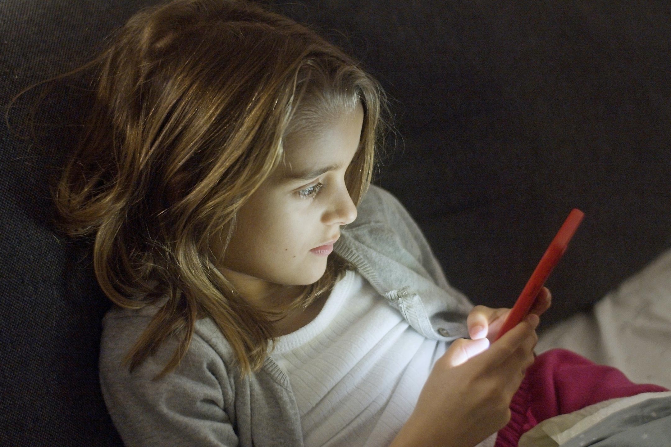young-girl-in-bed-on-smartphone2160