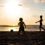 kids-playing-on-the-beach-in-sillouette