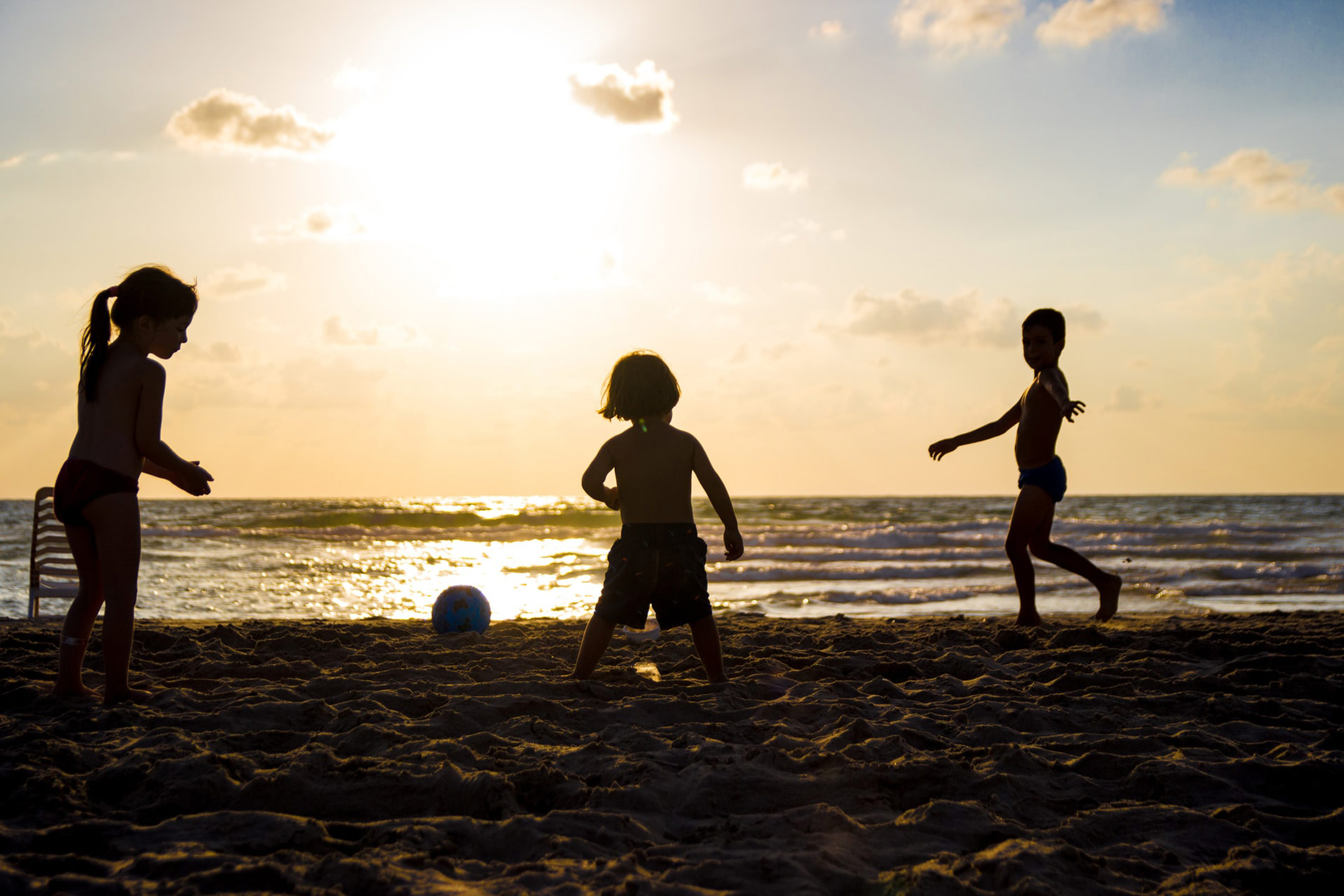 kids-playing-on-the-beach-in-sillouette