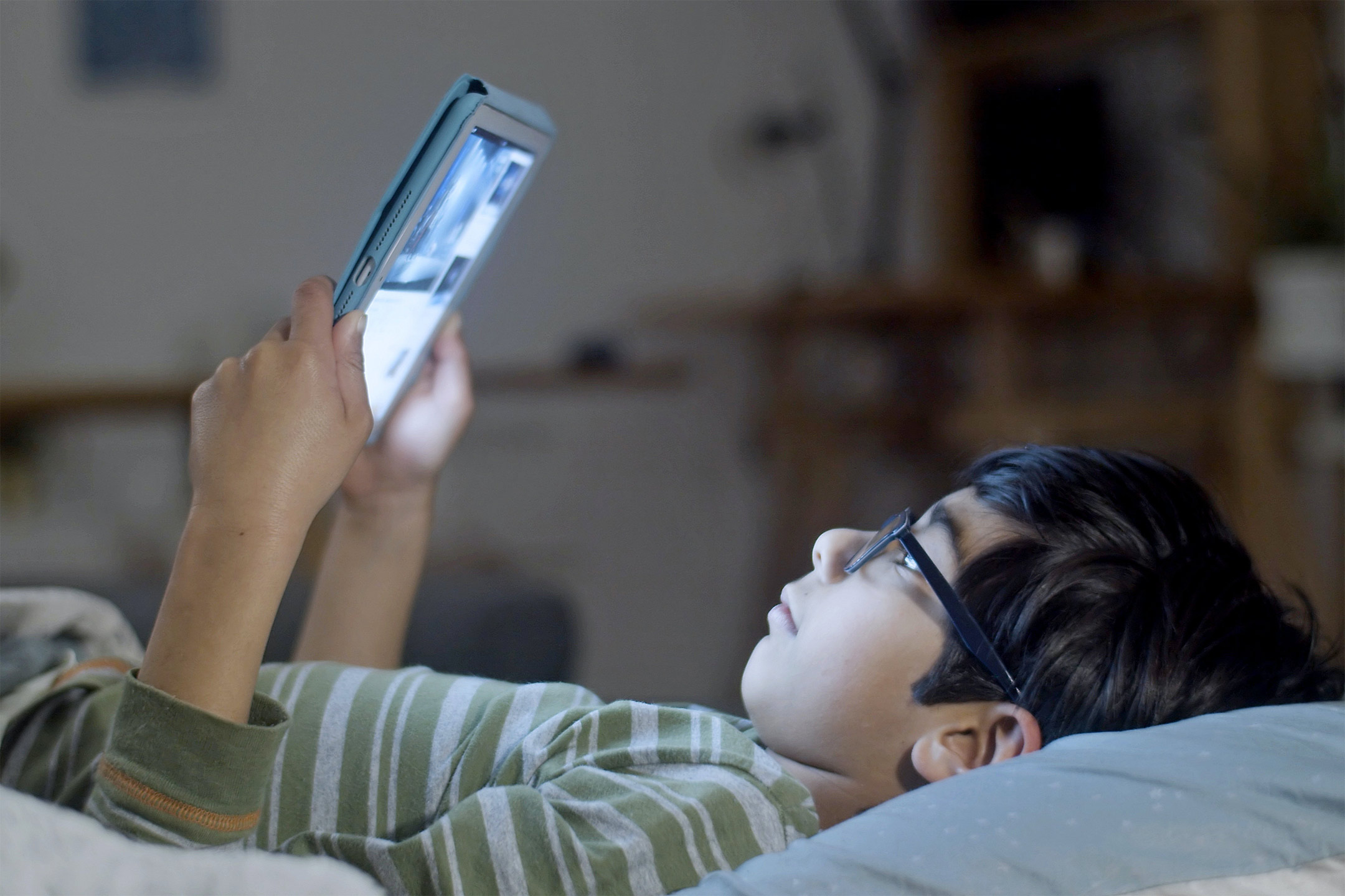 asian-boy-reading-tablet-in-bed2160
