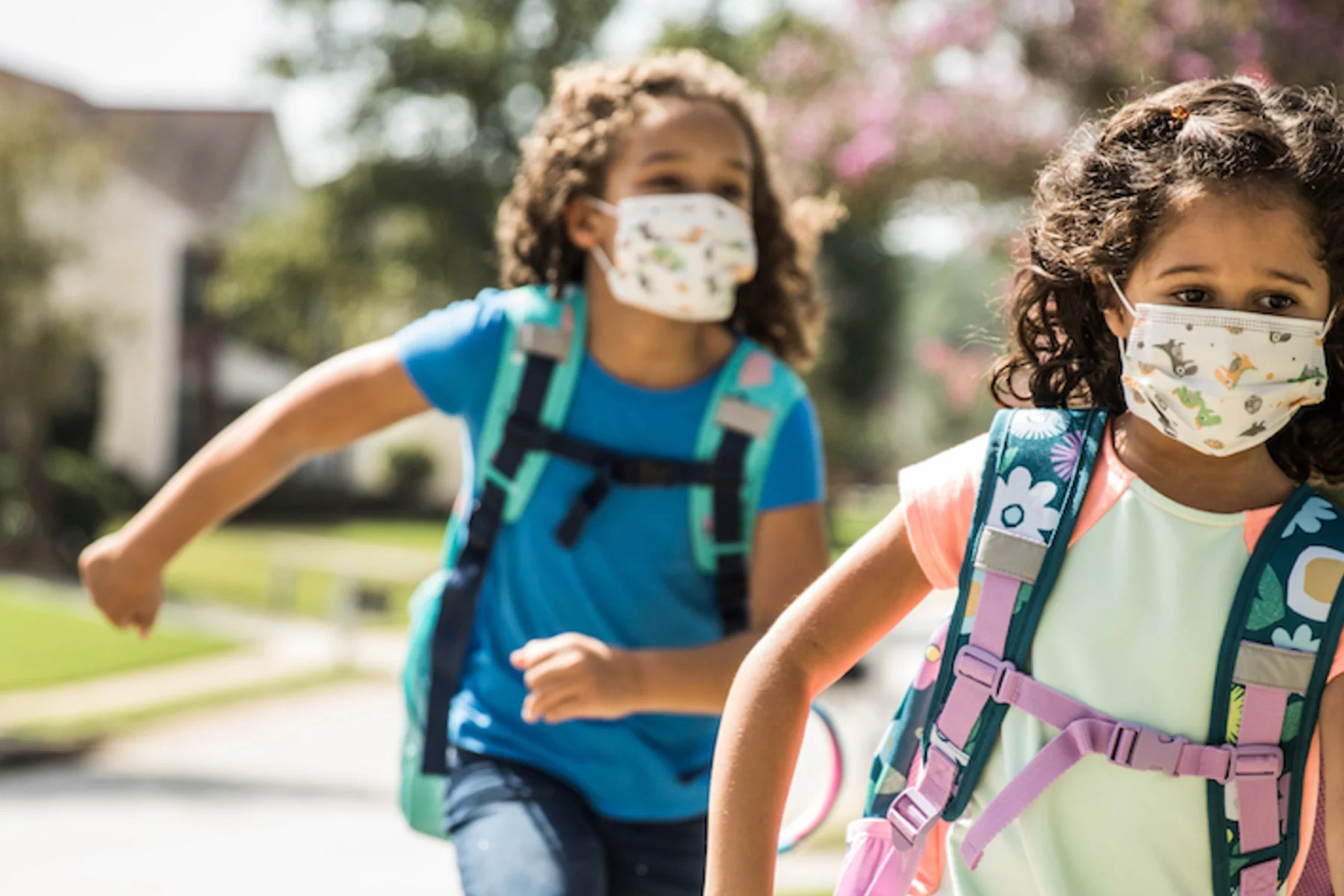 two-girls-running-with-masks-backpacks2160